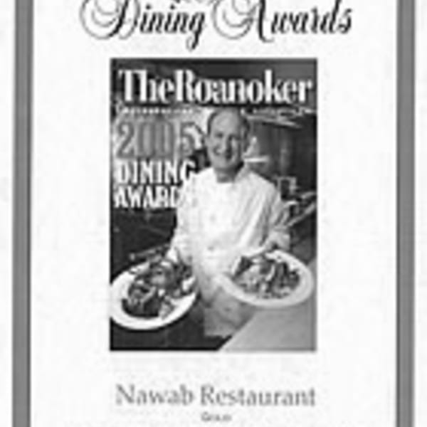 Chef holding two plates of Indian food, featured in a "The Roanoker" magazine dining award.